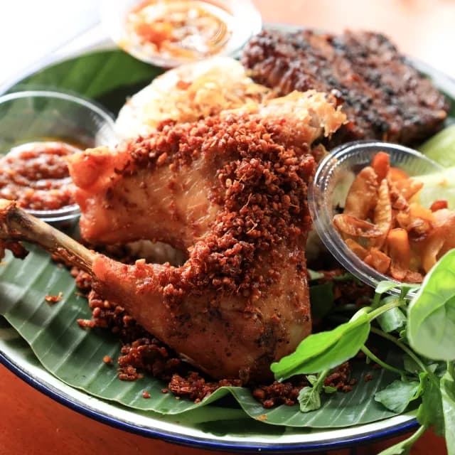 Malaysian grilled chicken rice platter served on a banana leaf